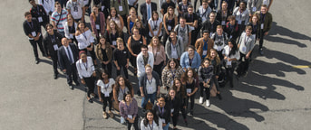 Gruppenfoto von Mitarbeitenden in Herzform aufgestellt Photo de groupe de collaborateurs formant un cœur